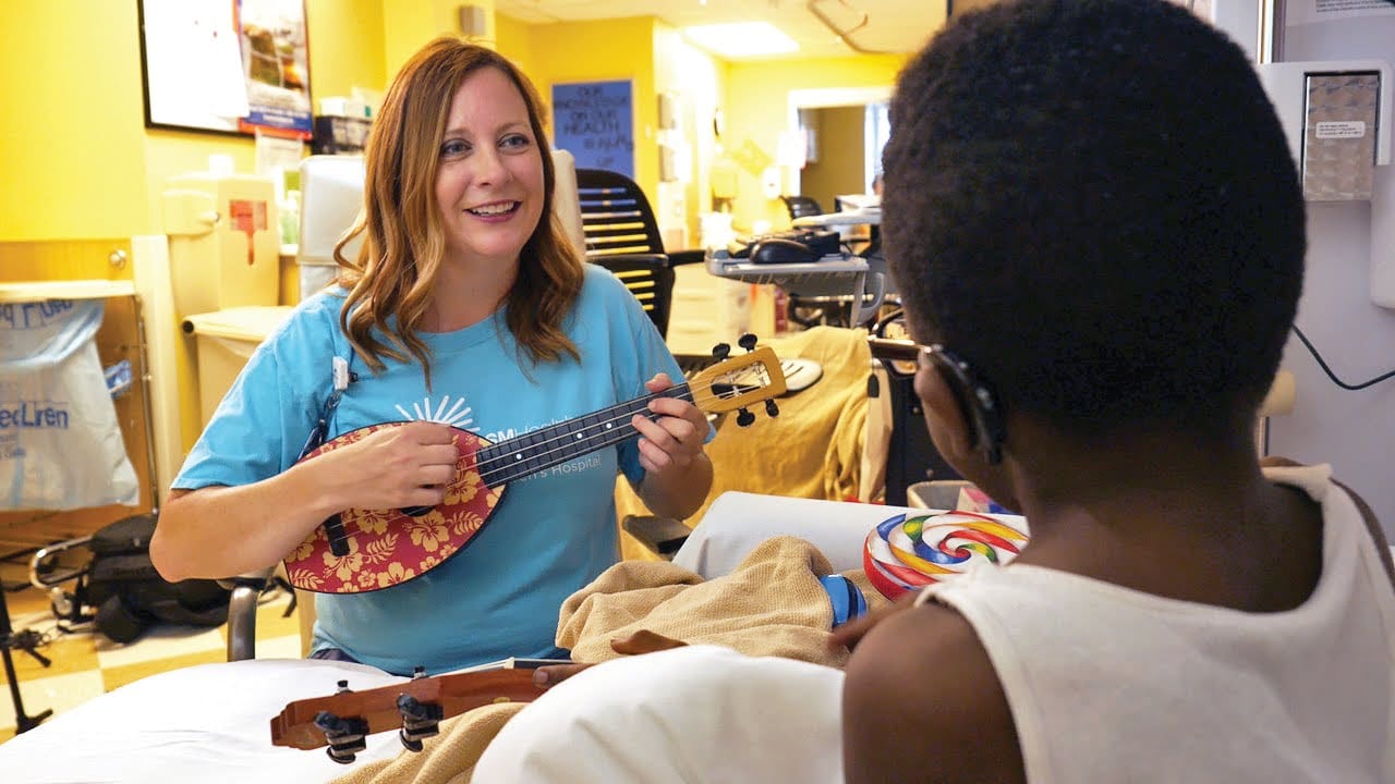 Kelli playing the ukulele for a patient